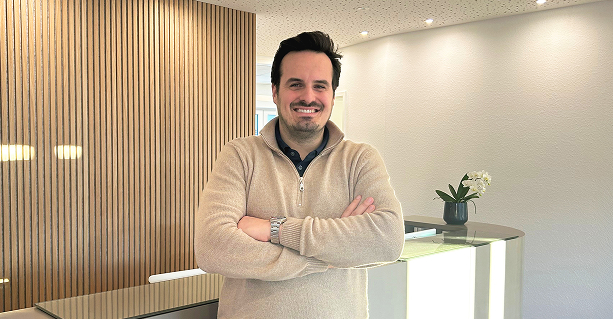 Ein Portrait von Dr. Jonas Müntze in warmer Ausleuchtung vor der Rezeption der Praxis.