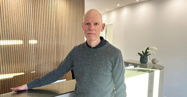 Ein Portrait von Dr. Stefan Teipel in warmer Ausleuchtung vor der Rezeption der Praxis.